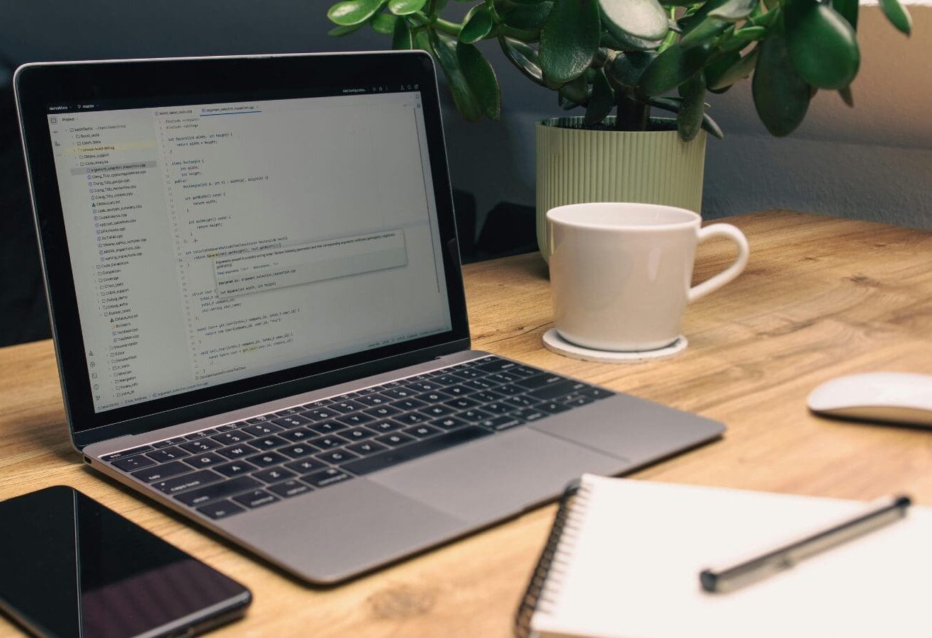 Laptop, coffee cup and plant representing looking for an email idea